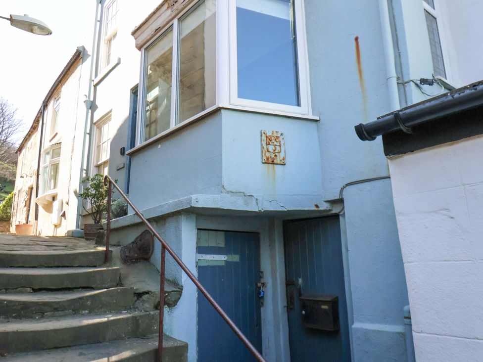 An entrance with stairs leading up to a blue door at Beachside Cottage Sandsend