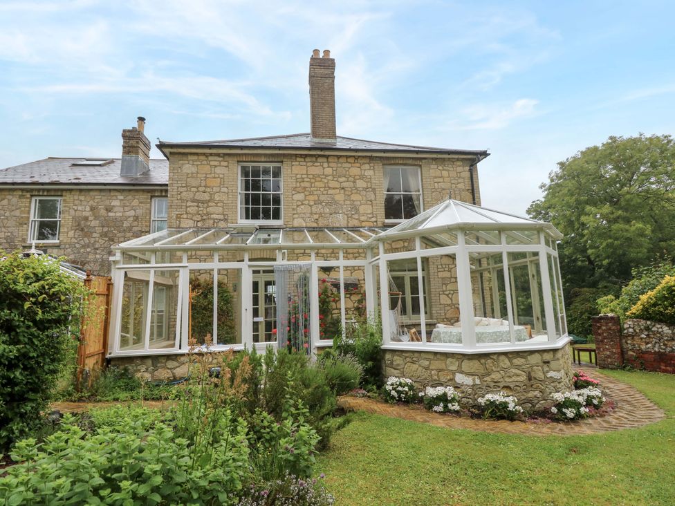 A conservatory with plants and pathways at Woodlands in Freshwater