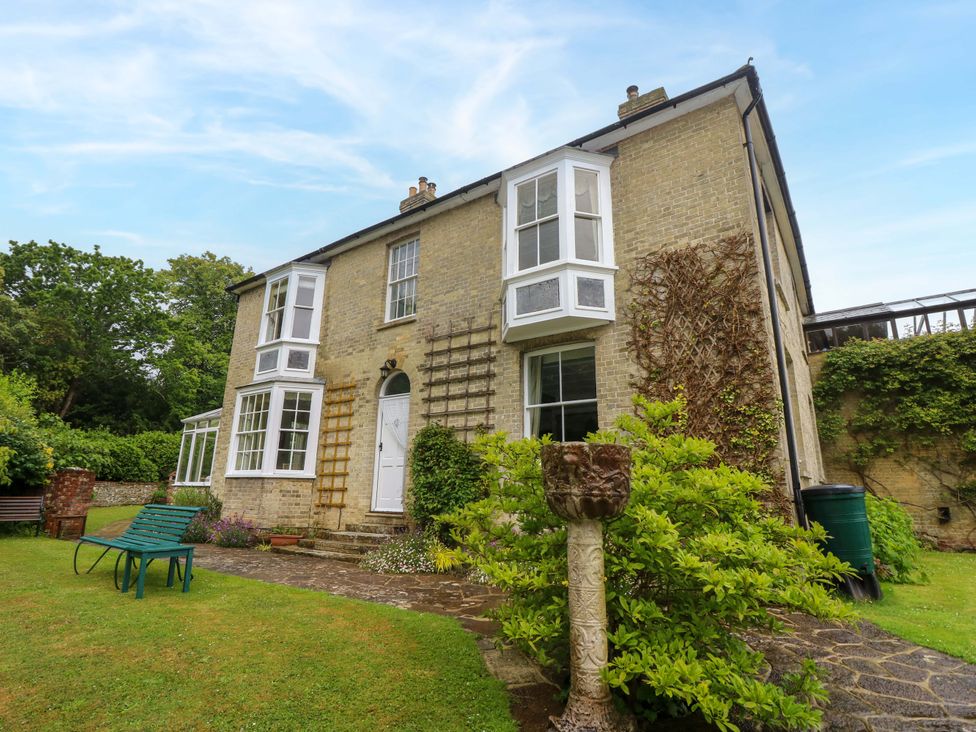 A house with garden seating and greenery at Woodlands in Freshwater