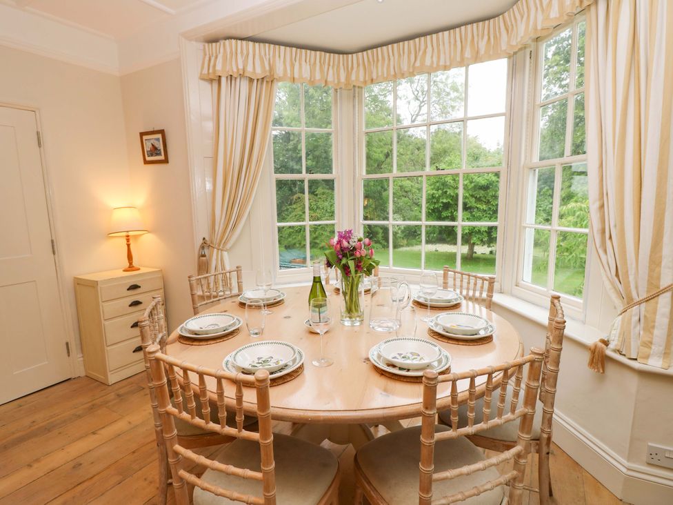 A dining room with a circular table and chairs at Woodlands in Freshwater