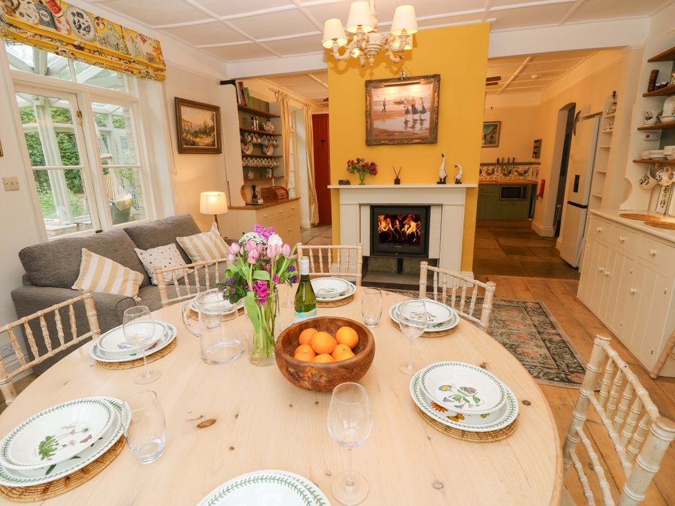 A dining room with a table set for meals at Woodlands in Freshwater