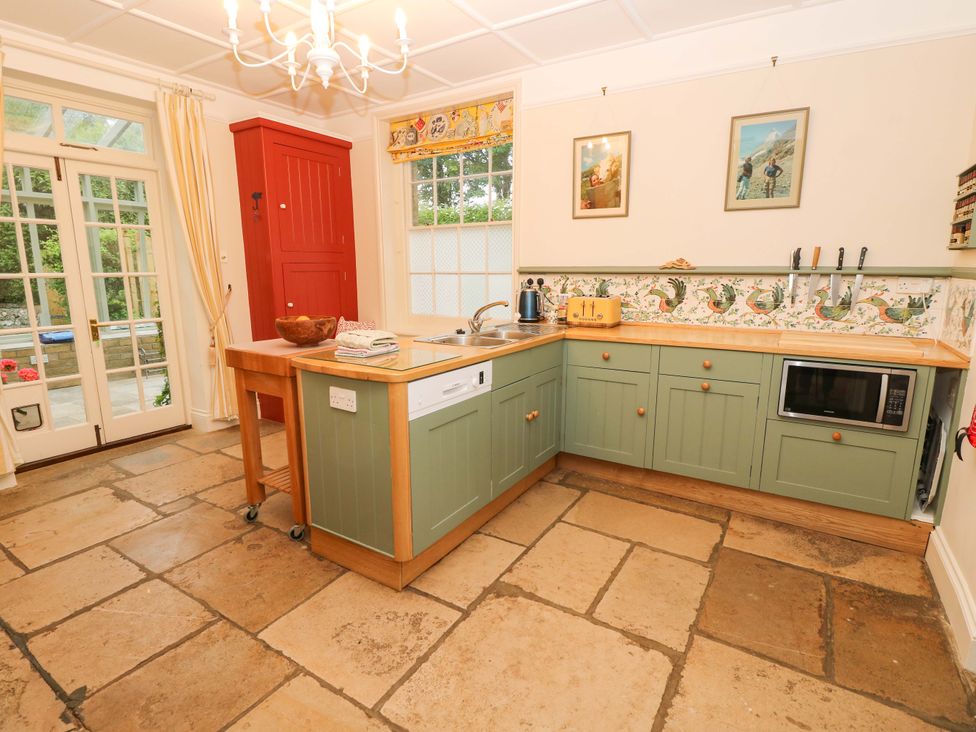 A kitchen with a green cabinet and appliances at Woodlands in Freshwater