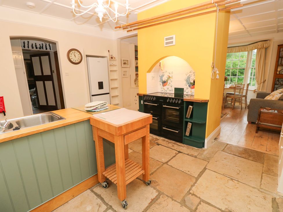 A kitchen with a sink, oven, and refrigerator at Woodlands in Freshwater
