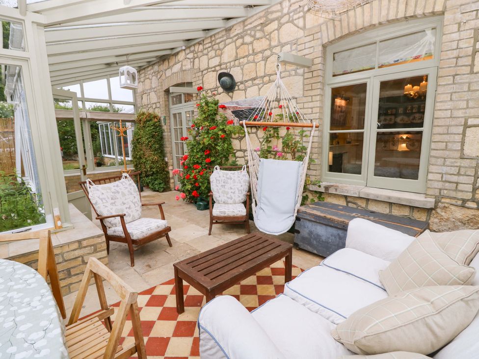 A conservatory with seating and plants at Woodlands Freshwater