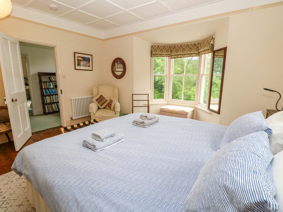 A bedroom with a bed and chair at Woodlands in Freshwater