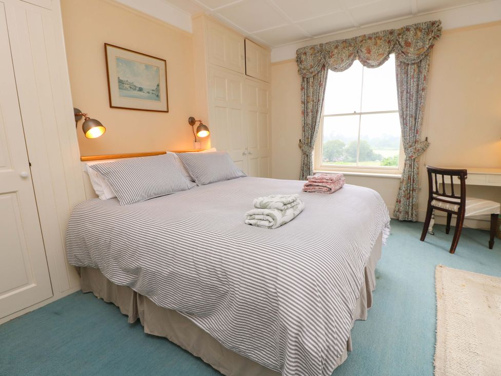 A bedroom with a bed, table, and chair at Woodlands in Freshwater