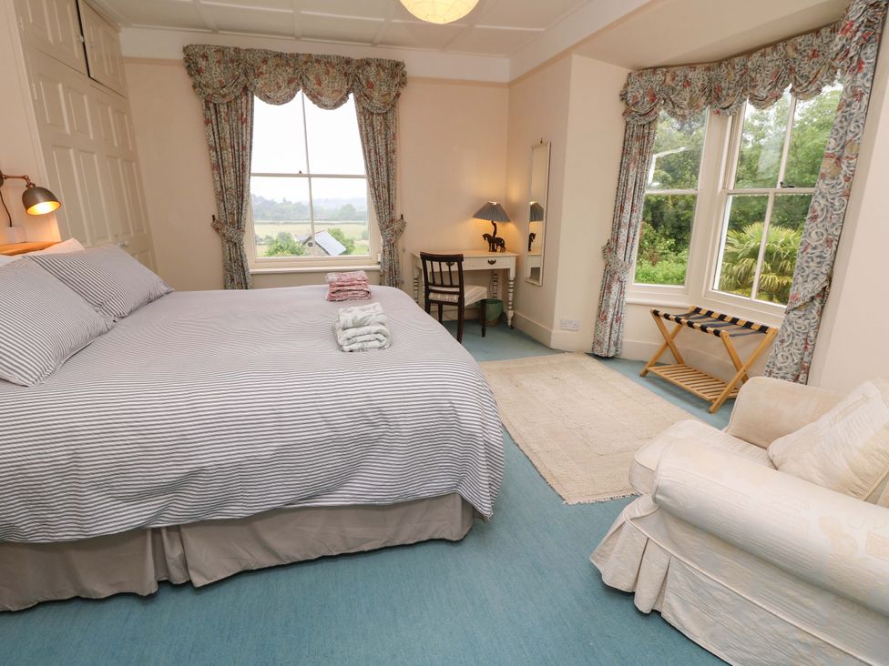 A bedroom with a bed and desk at Woodlands in Freshwater