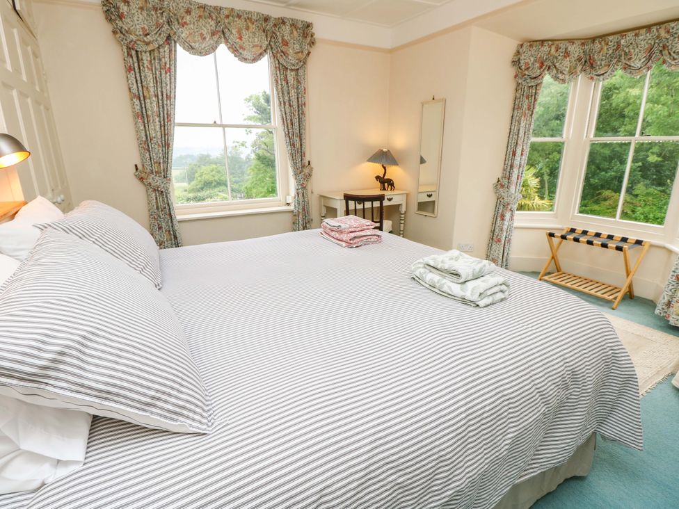 A bedroom with a bed and windows at Woodlands in Freshwater