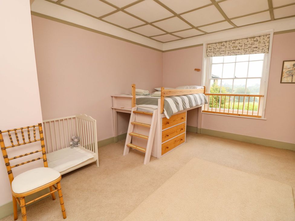 A bedroom with a bunk bed and crib at Woodlands in Freshwater