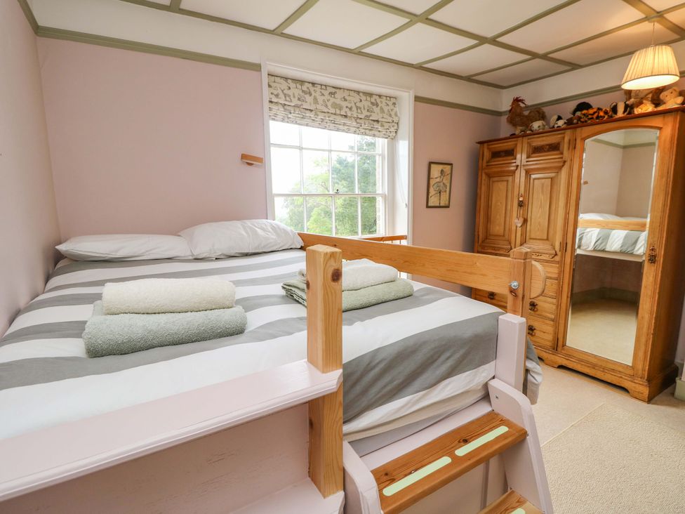 A bedroom with a bed and wardrobe at Woodlands in Freshwater
