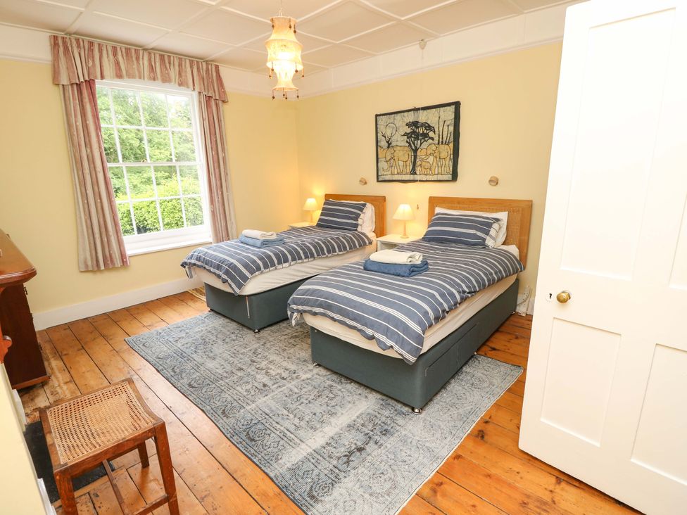 A bedroom with twin beds and a window at Woodlands in Freshwater