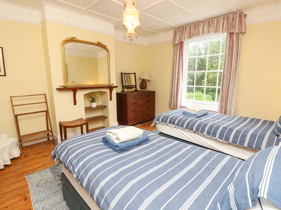 A bedroom with two beds and a window at Woodlands in Freshwater