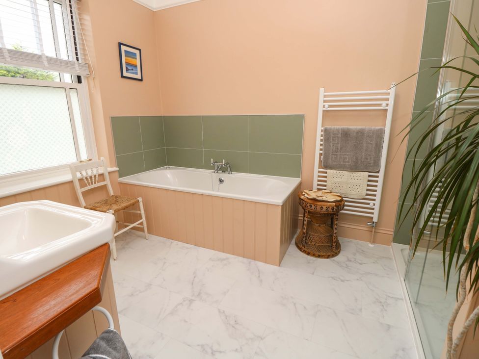 A bathroom with a bathtub and sink at Woodlands in Freshwater