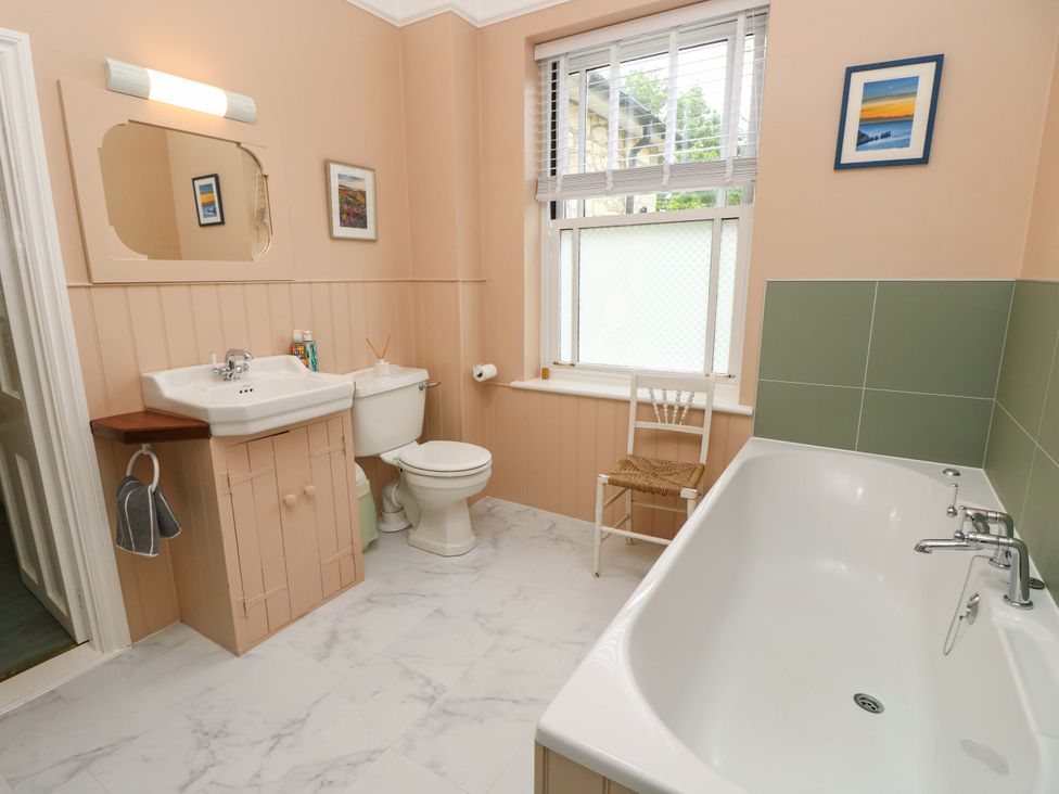 A bathroom with a bathtub, toilet, and sink at Woodlands in Freshwater