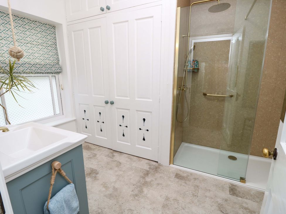 A bathroom with a shower and sink at Woodlands in Freshwater