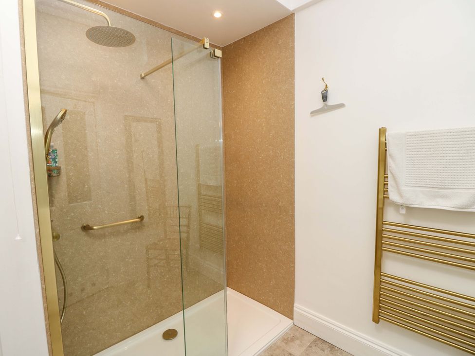 A bathroom with a shower and towel rail at Woodlands Freshwater