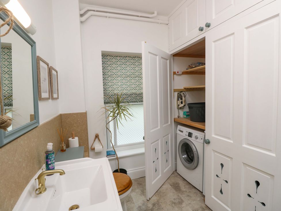 A bathroom with a sink and laundry machine at Woodlands in Freshwater