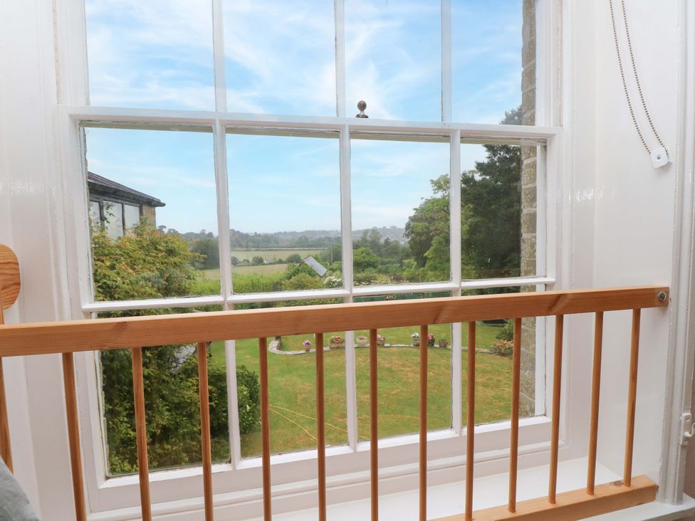 A view from a window showing greenery and fields at Woodlands in Freshwater