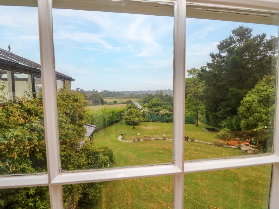 A view of a garden with trees and grass at Woodlands in Freshwater