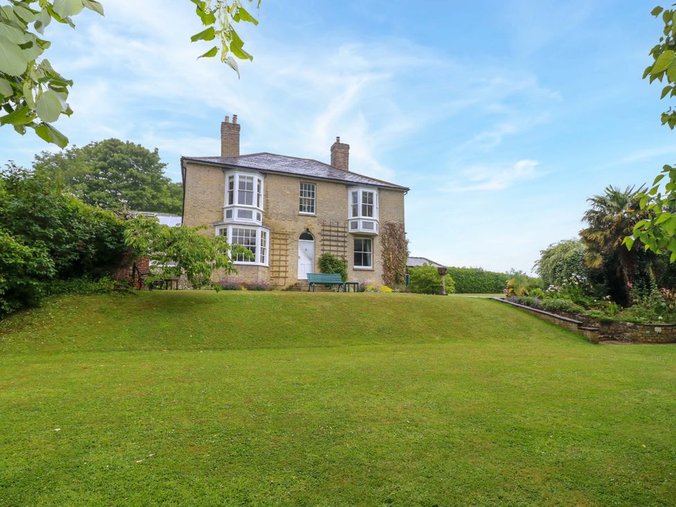 A house with a lawn and trees at Woodlands Freshwater
