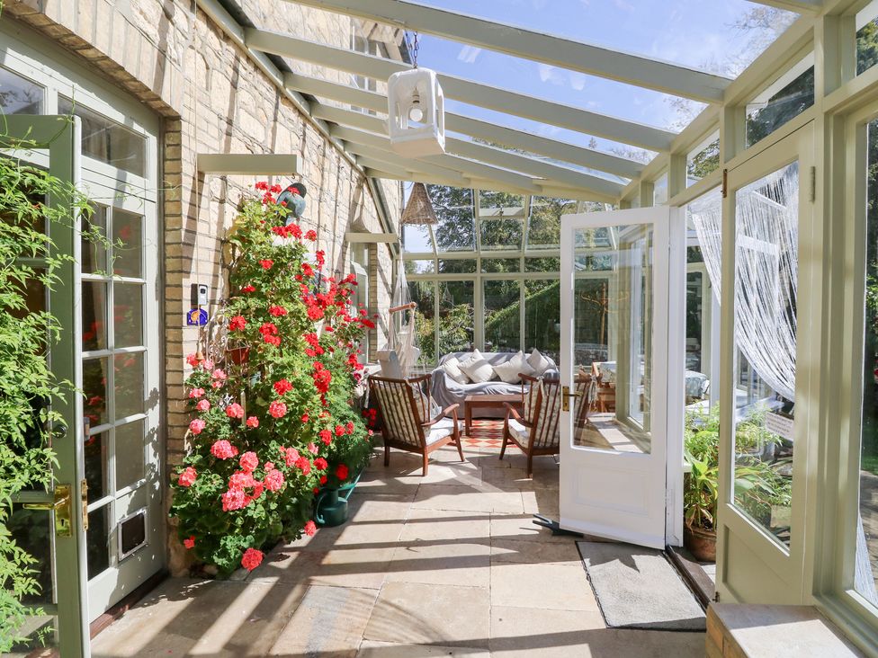 A conservatory with seating and plants at Woodlands Freshwater
