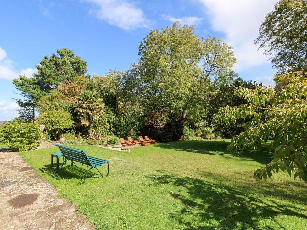 A garden with chairs on grass at Woodlands in Freshwater