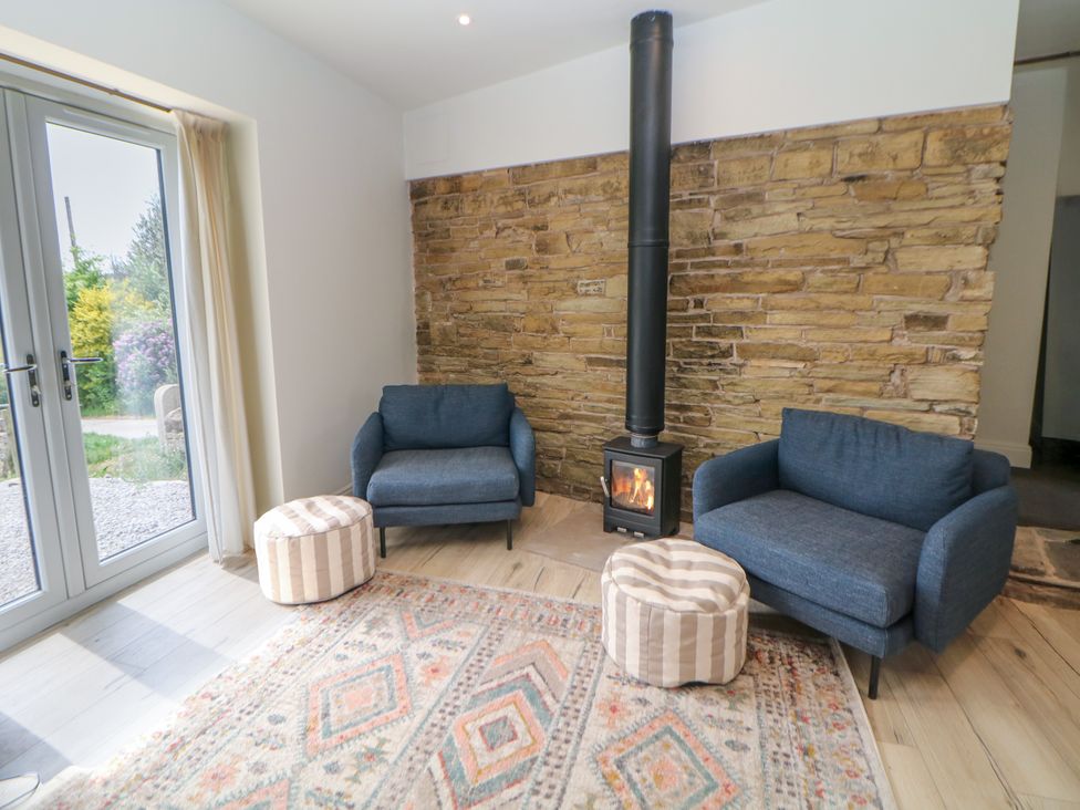 A living room with two sofas and a fireplace at The Plucking Shed in Stockport