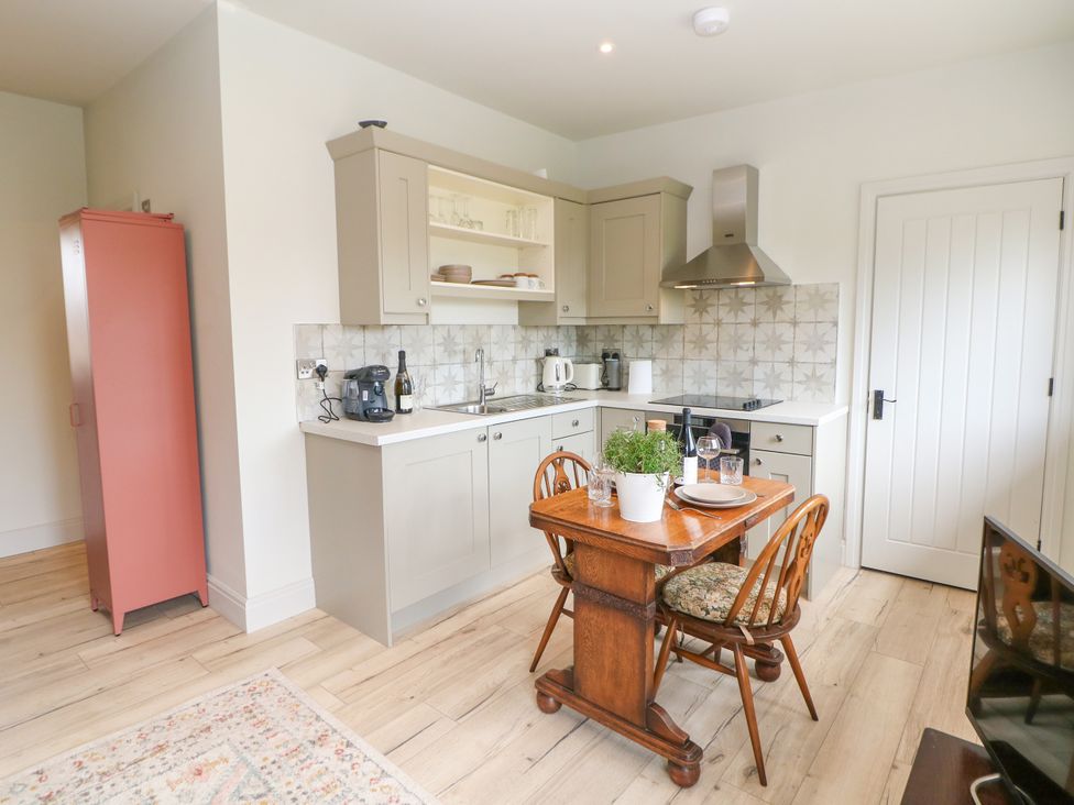 A kitchen with a table and chairs at The Plucking Shed in Stockport