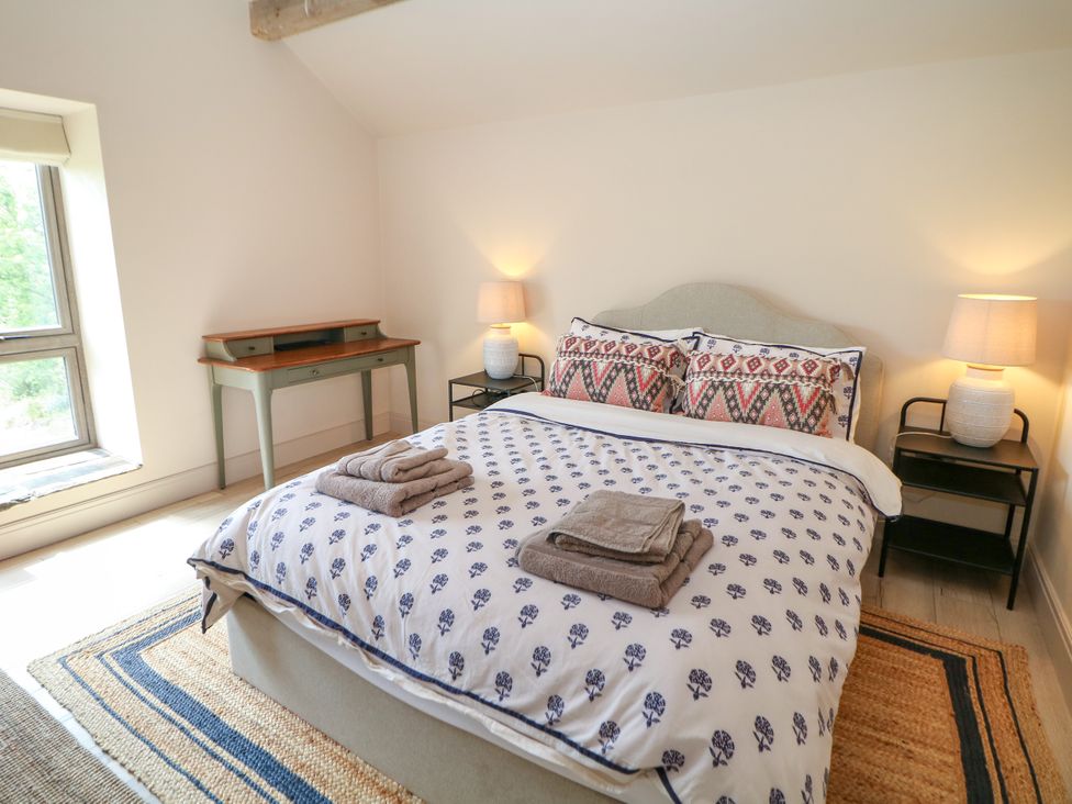 A bedroom with a bed and desk at The Plucking Shed in Stockport