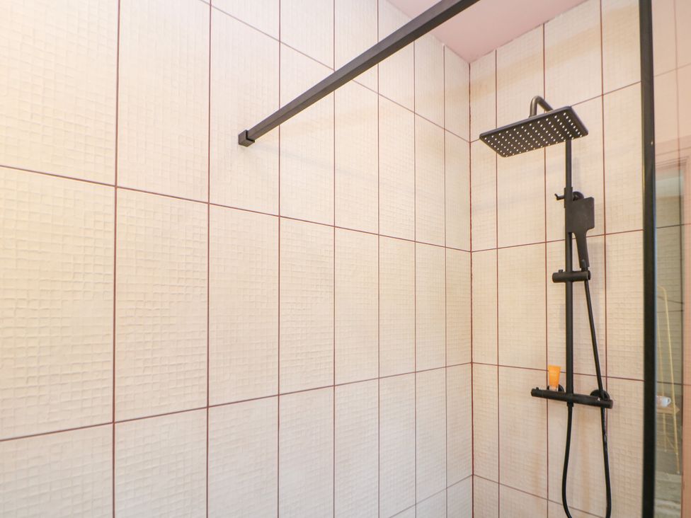 A shower with tiled walls and fixtures at The Plucking Shed in Stockport