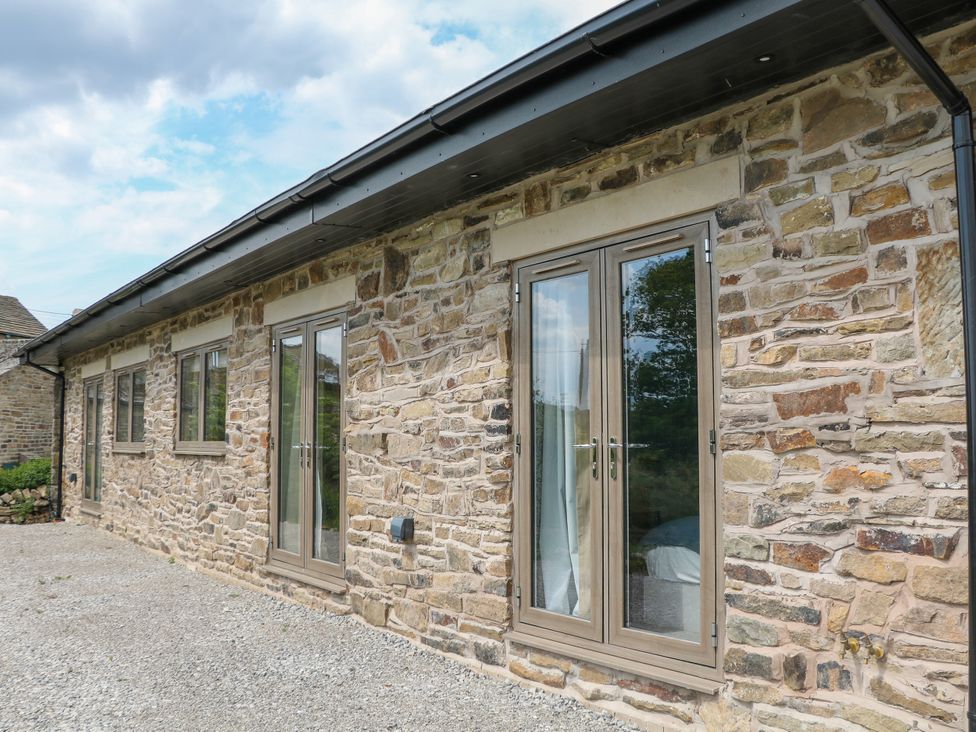 An exterior view of a stone building with windows at The Plucking Shed in Stockport