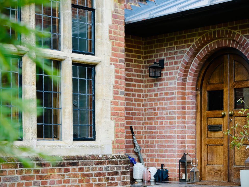 An entrance area with a wooden door and brick wall at Higginson House in Marlow