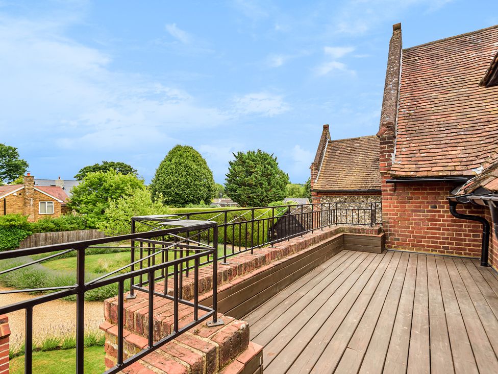 An outdoor balcony with railings and surrounding trees at Higginson House in Marlow