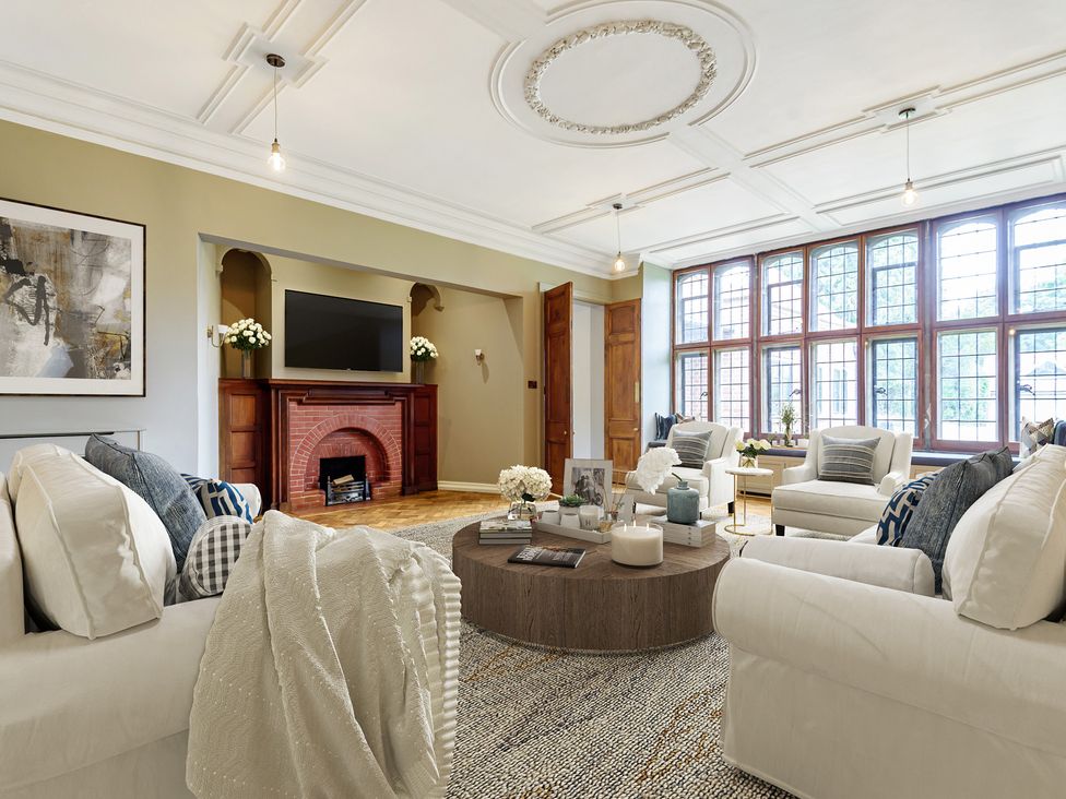 A living room with a fireplace and television at Higginson House in Marlow