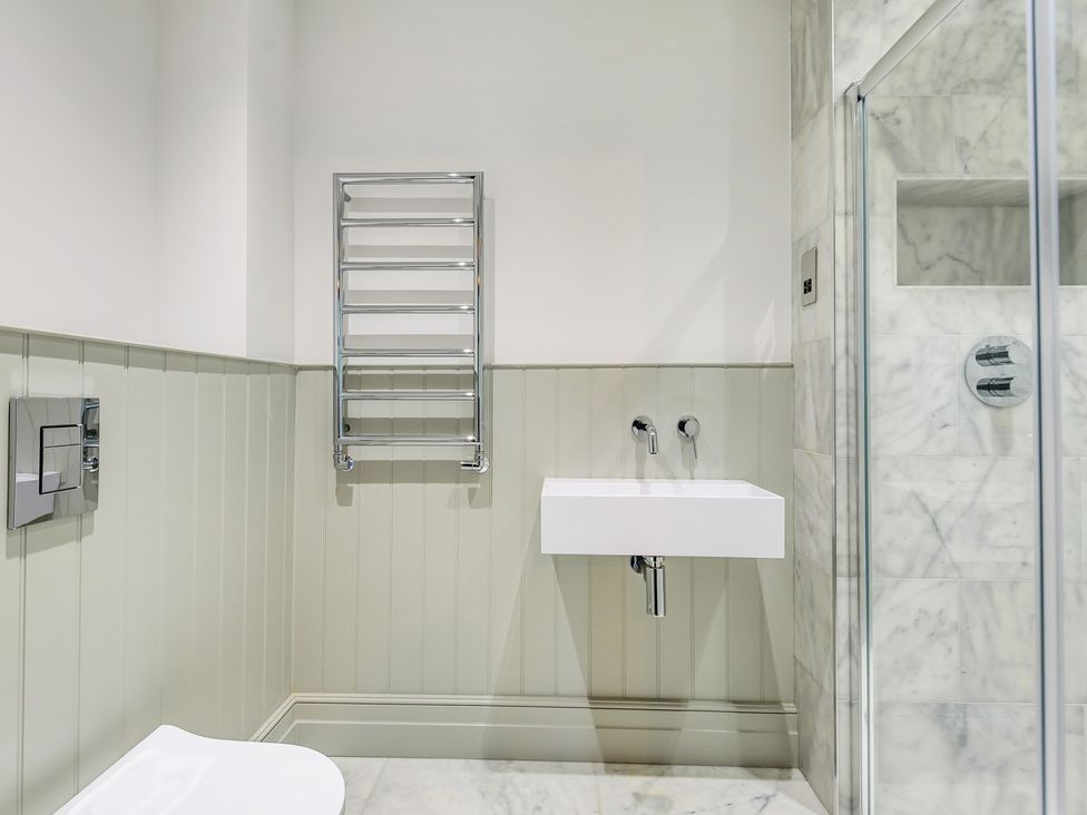 A bathroom featuring a toilet, sink, towel rail, and shower at Higginson House in Marlow