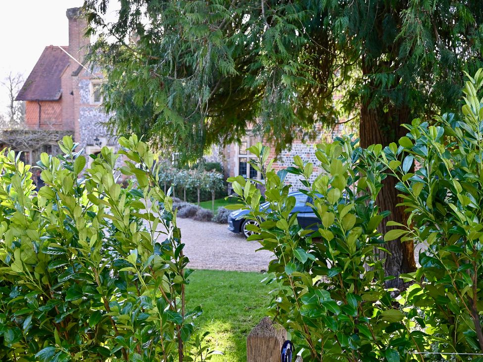 An outdoor area with bushes and a car in the driveway at Higginson House in Marlow