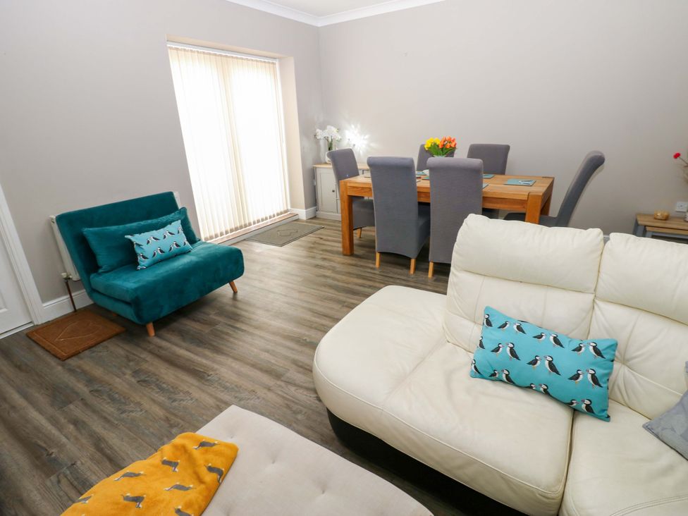 A living room with a sofa and dining table at Amblers Rest in Amble