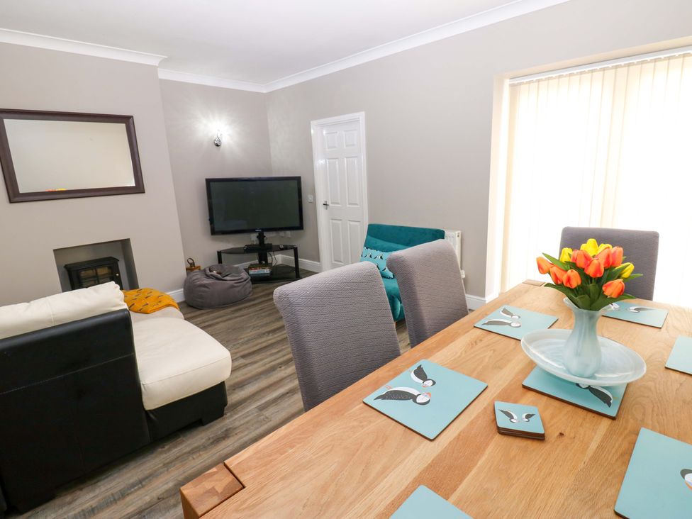 A dining table with flowers and chairs at Amblers Rest in Amble
