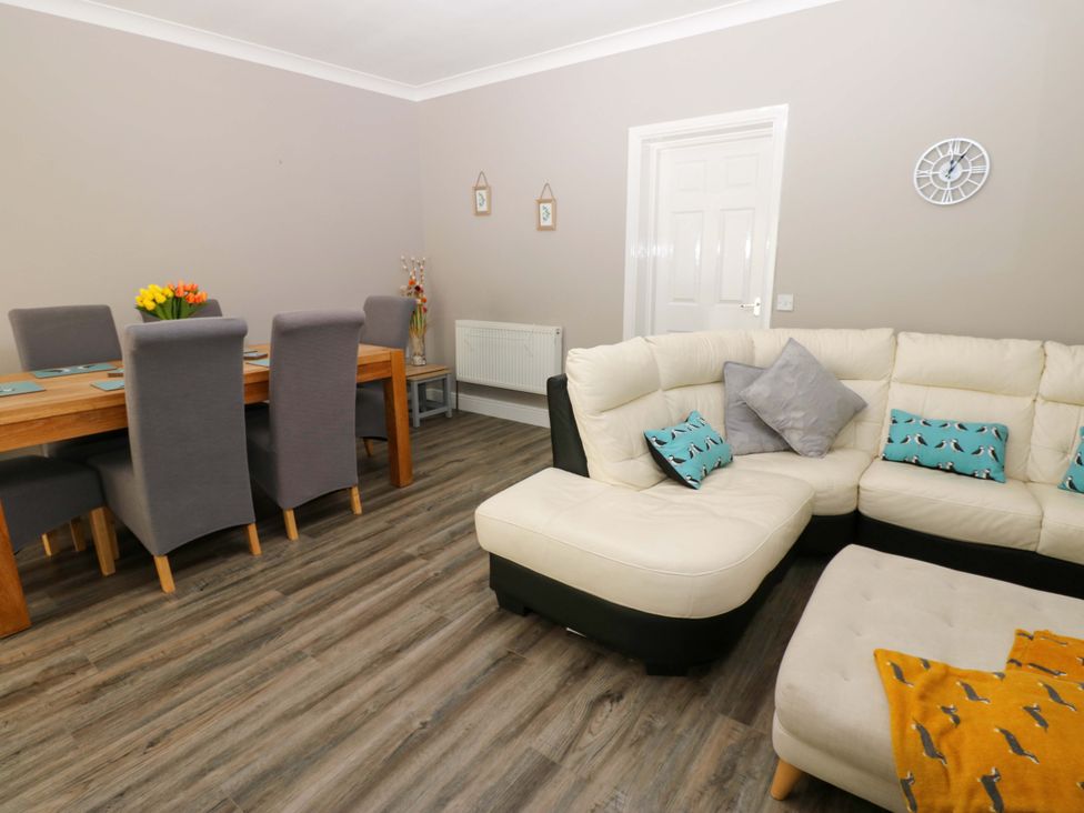 A living room and dining area with a table and chairs at Amblers Rest in Amble