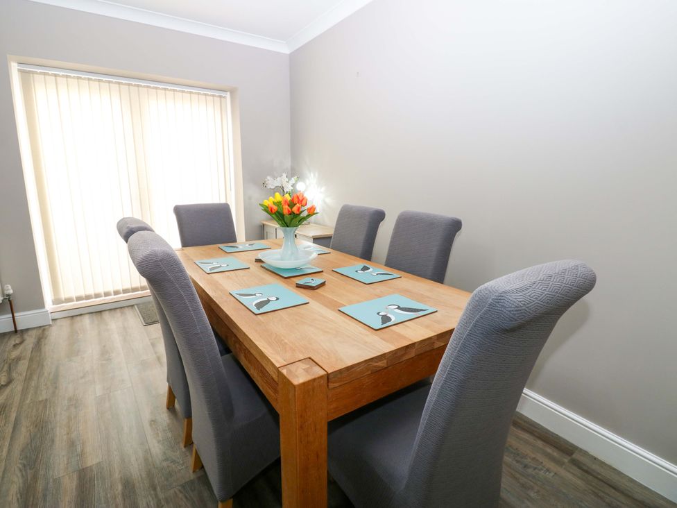 A dining room with a table and chairs at Amblers Rest in Amble