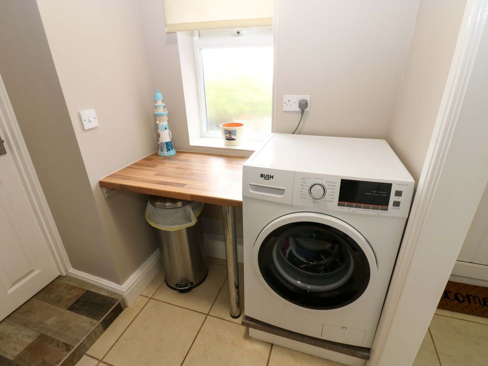 A laundry room with a washing machine and worktop at Amblers Rest in Amble