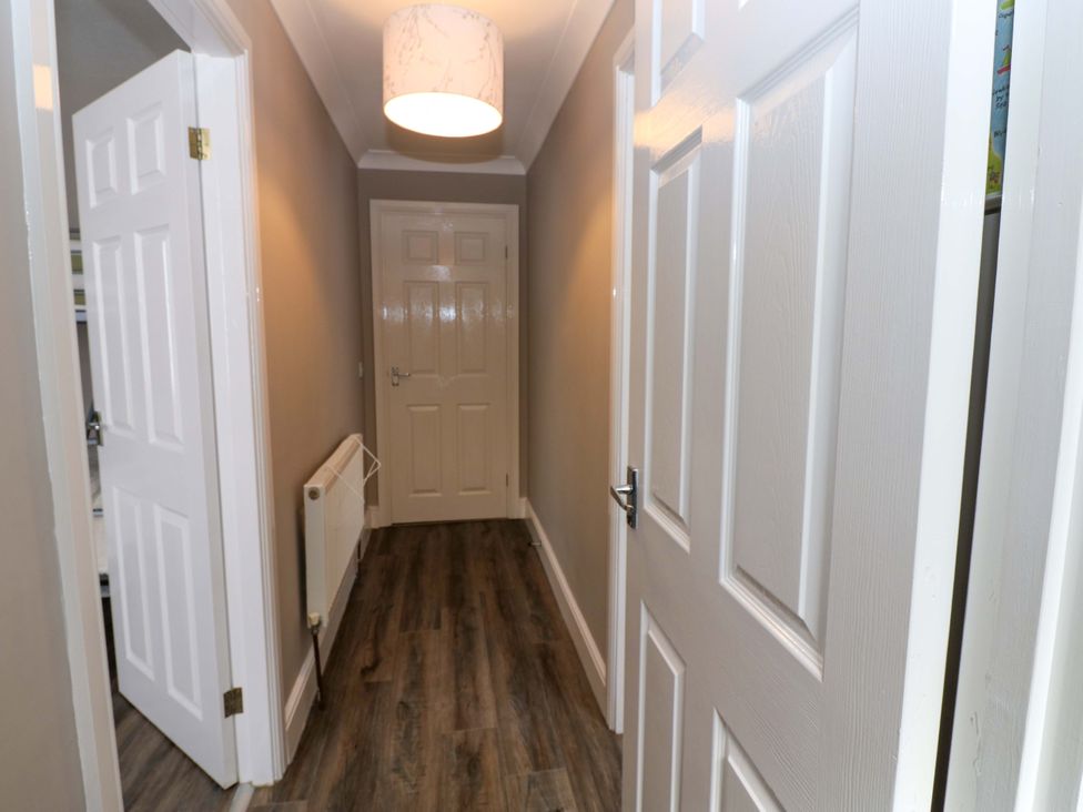 A hallway with doors and a ceiling light at Amblers Rest in Amble