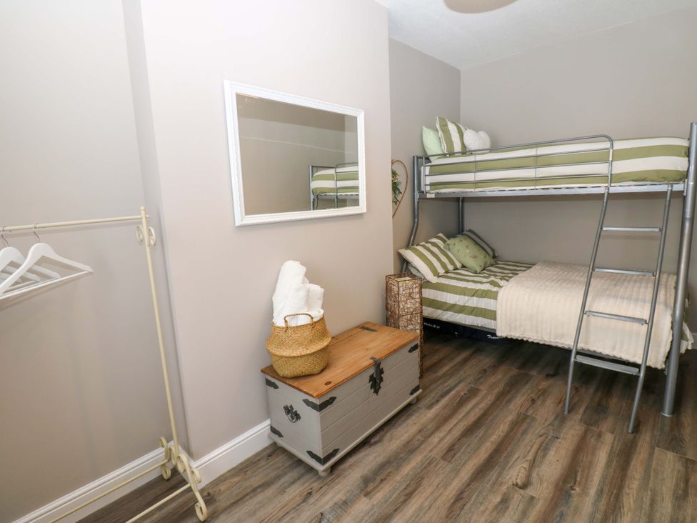 A bedroom with a bunk bed and a single bed at Amblers Rest in Amble
