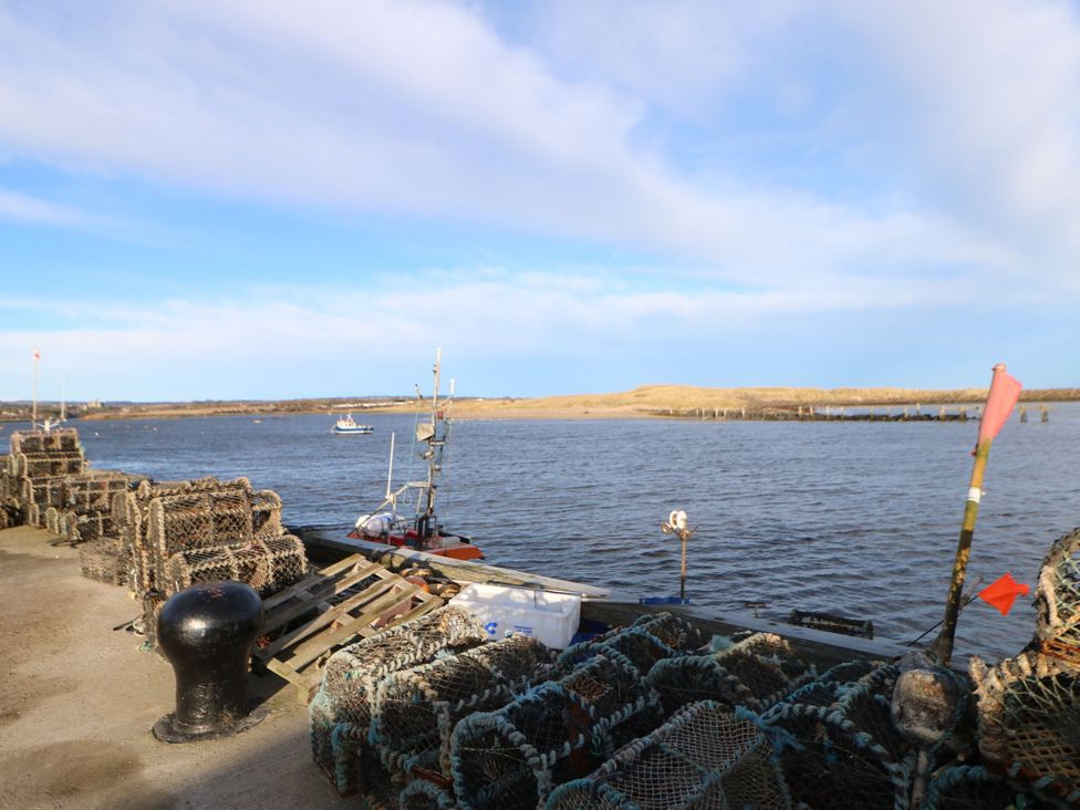 A fishing boat near lobster traps at Amblers Rest in Amble