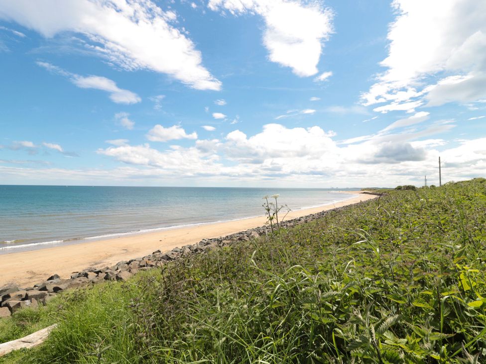 A beach with sand and water at Amblers Rest in Amble