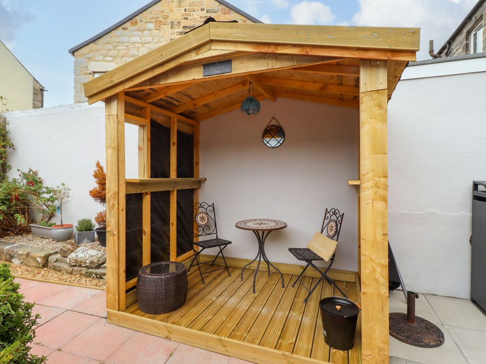 A garden shed with two chairs and a table at Amblers Rest in Amble