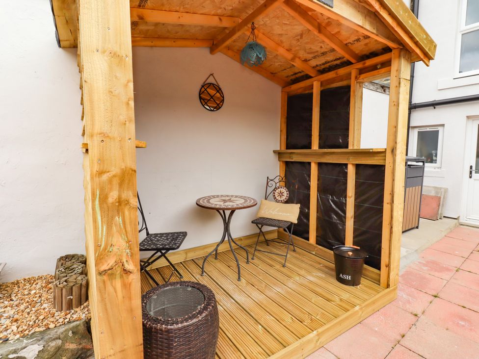 An outdoor seating area with a wooden structure and table at Amblers Rest in Amble