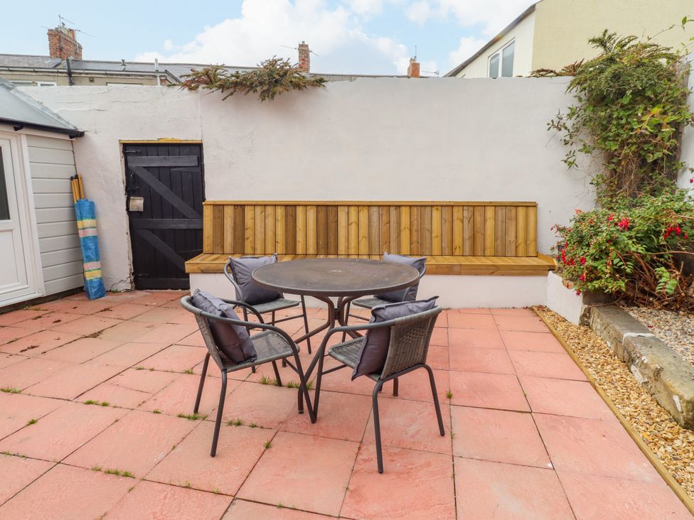 A garden with a table and chairs at Amblers Rest in Amble