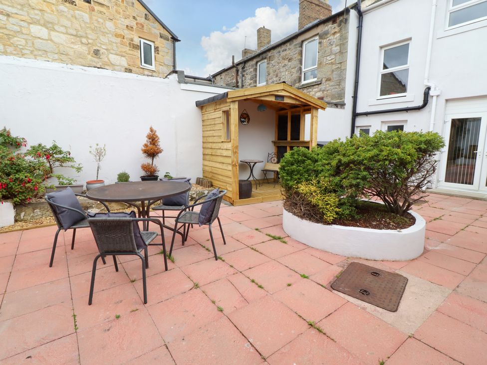 A garden with a table and chairs and a shed at Amblers Rest in Amble