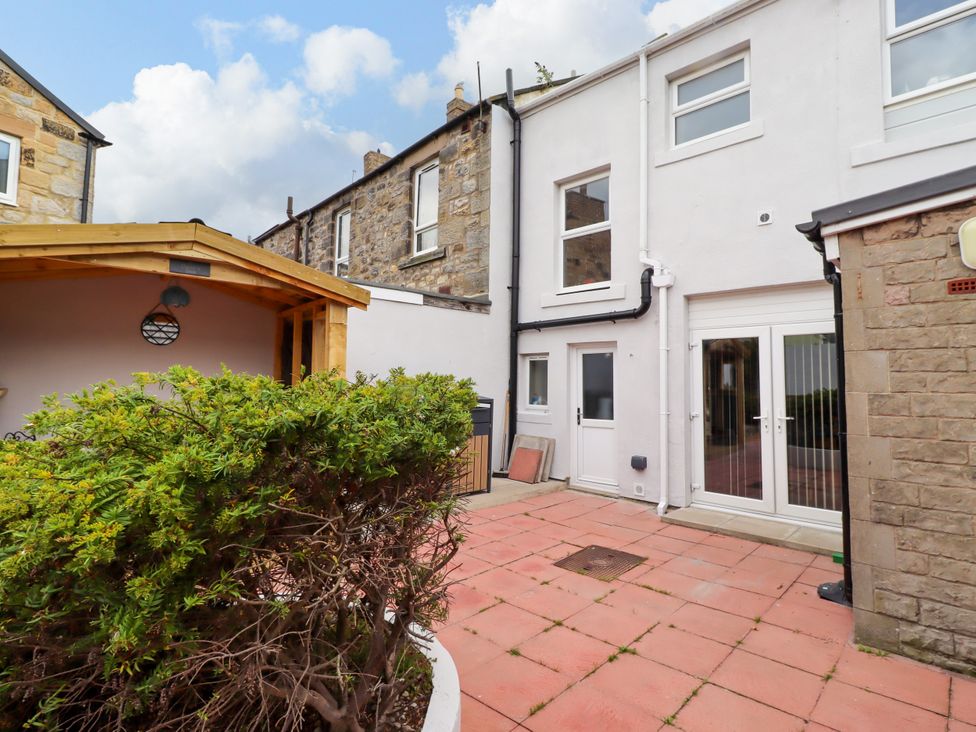 A garden area with a wooden structure and patio at Amblers Rest in Amble